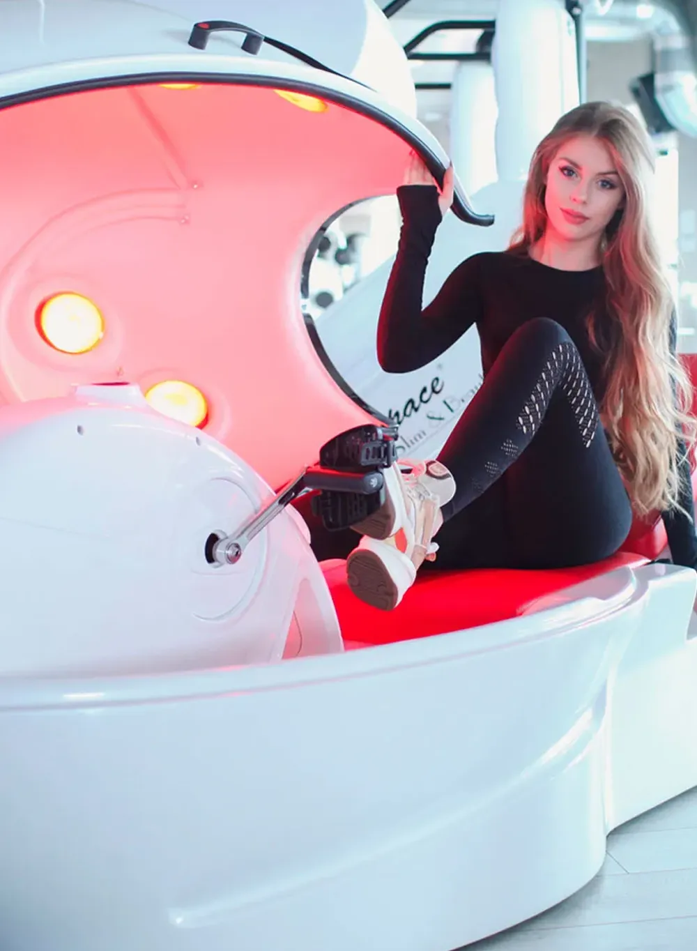 Young woman entering a vacuum infrared capsule for a Body Space® slimming session