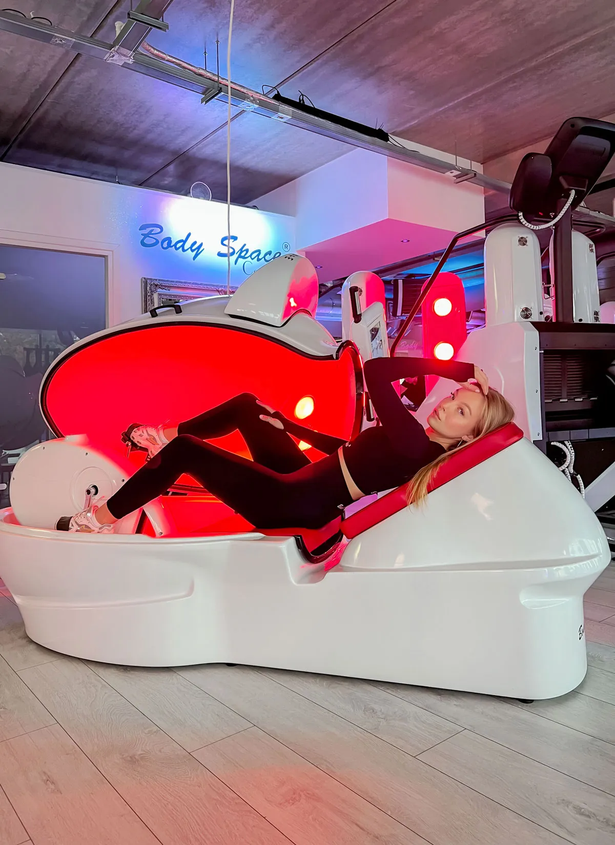 Woman exercising inside a Body Space® vacuum infrared capsule during a slimming workout