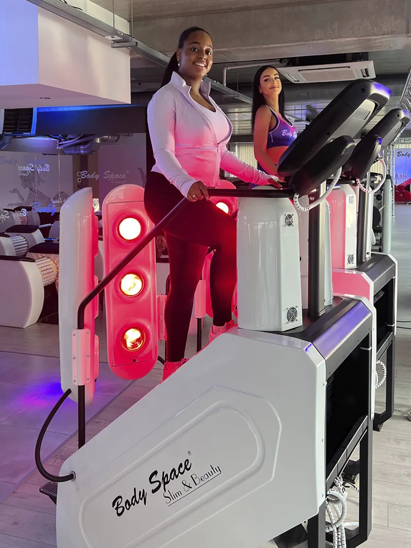 Two women training on Body Space® InfraRed Stair Climbers – cardio and red light therapy in action